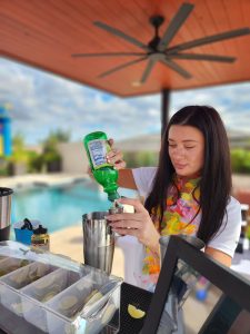 Certified Event bartender pouring a premium cocktail at a poolside bar in Scottsdale