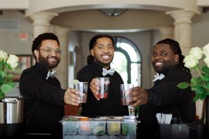 Three mobile bartenders from The House of Drinks holding drinks.